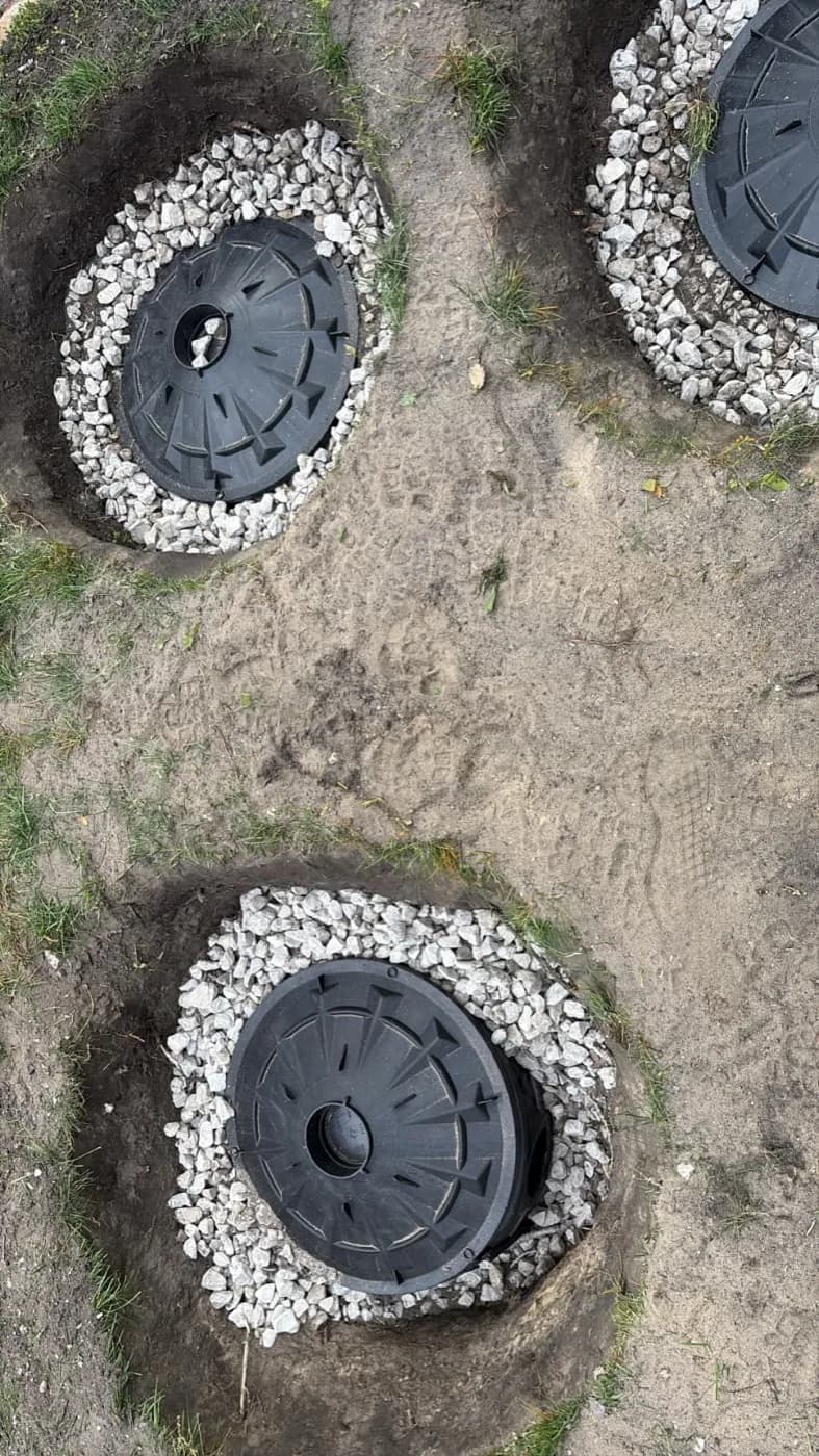 Three drywell basins set in gravel rings, seen from above