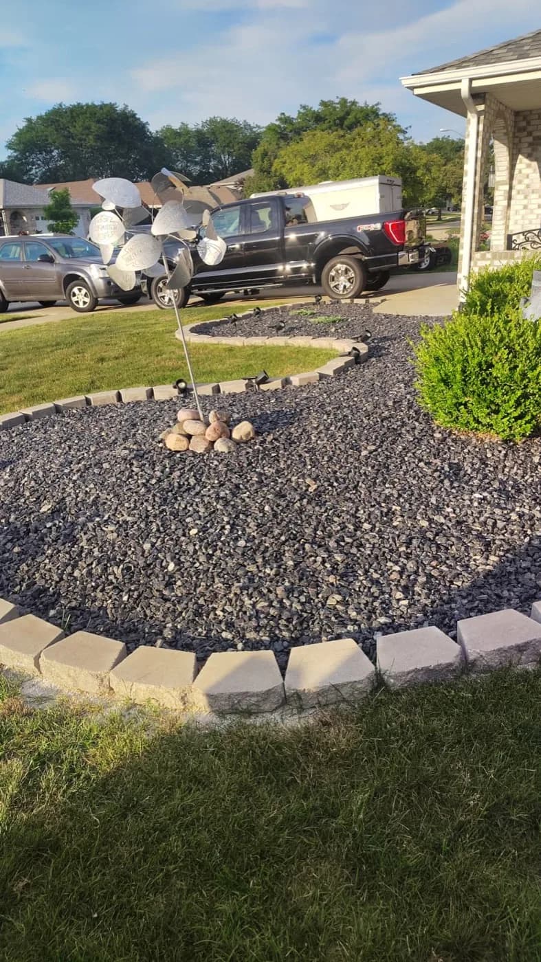 Island bed of decorative stone edged in pavers